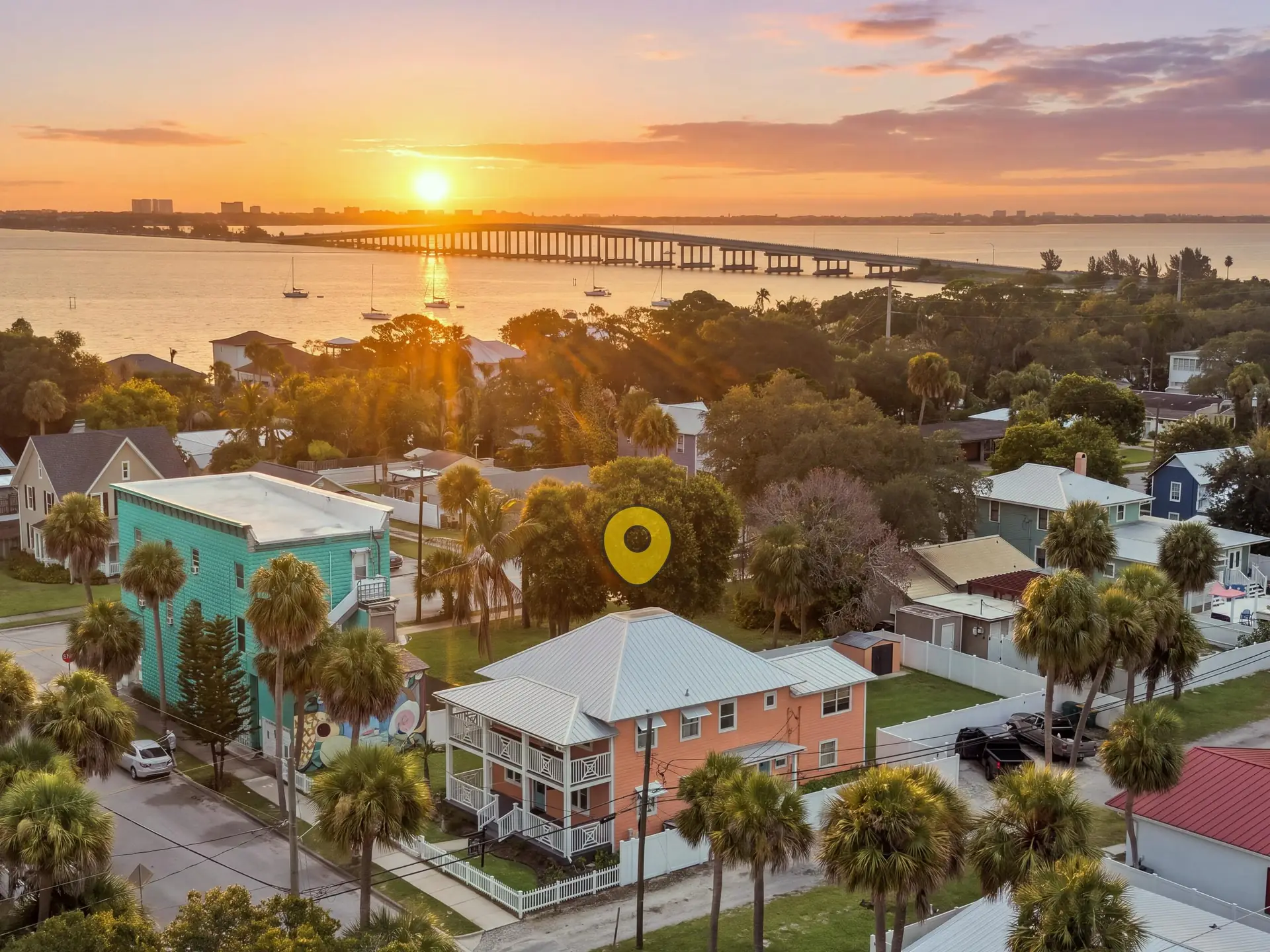 Aerial view at sunset over Melbourne's Eau Gallie Arts District, with the home just below the Eau Gallie Causeway and sailboats moored on the Indian River Lagoon